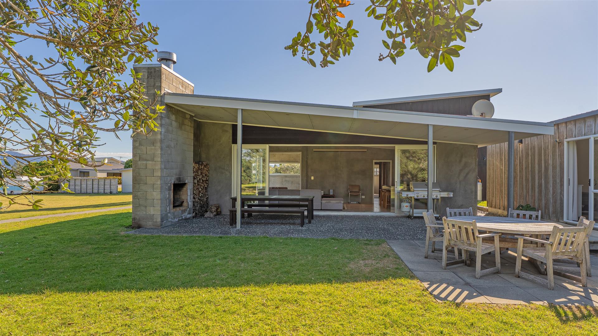 Open outdoor living area, fireplace and family dining tables at 111 Kauri Crescent