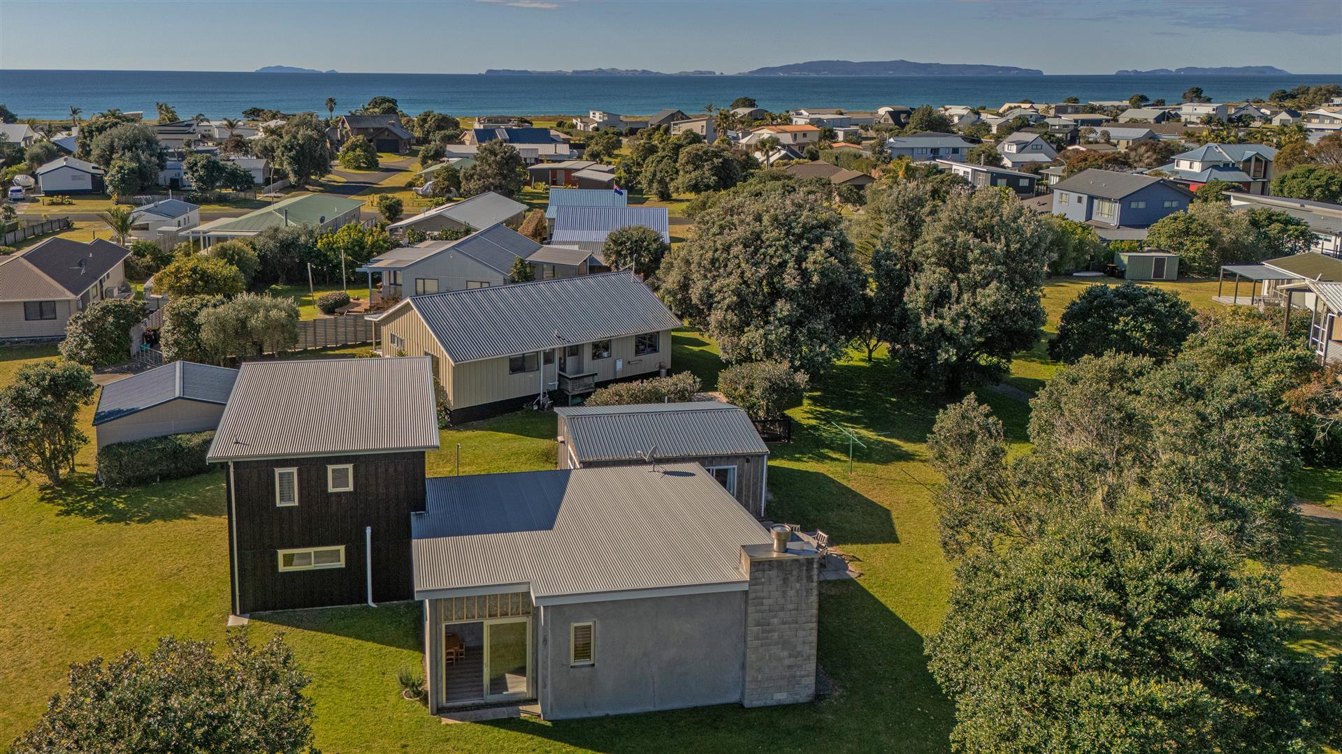 Aerial photograph of 111 Kauri Crescent with the Matarangi coastline beyond